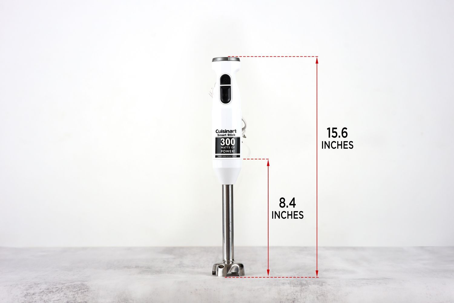 The Cuisinart Smart Stick 2-speed hand blender standing on top of its blending shaft on a gray table, with the length of the blending shaft being noted to the side as 8.4 inches, and the total length of the unit as 15.6 inches.