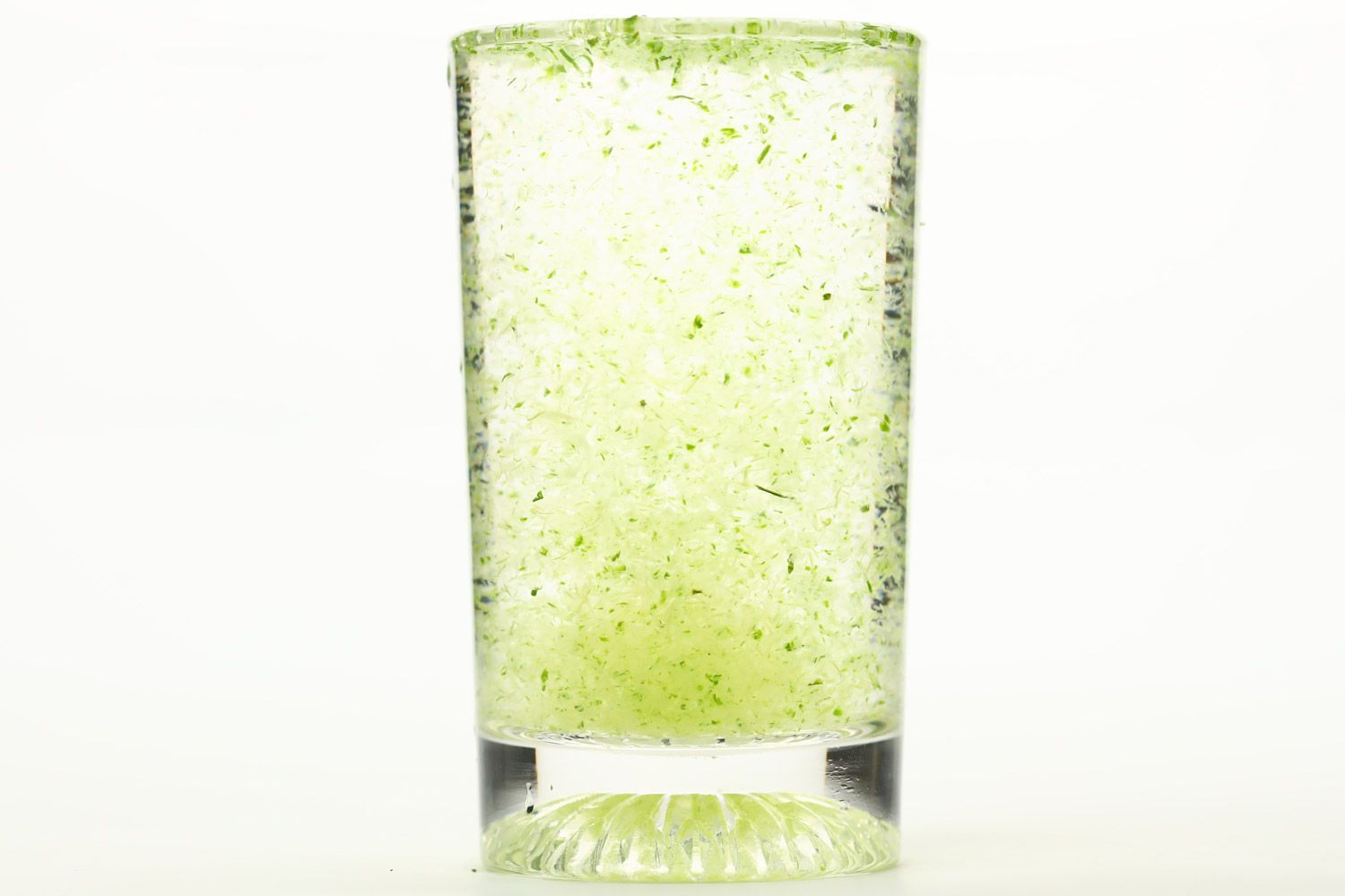 A glass of water with fibrous green pulp produced by the NutriBullet single-serve blender.