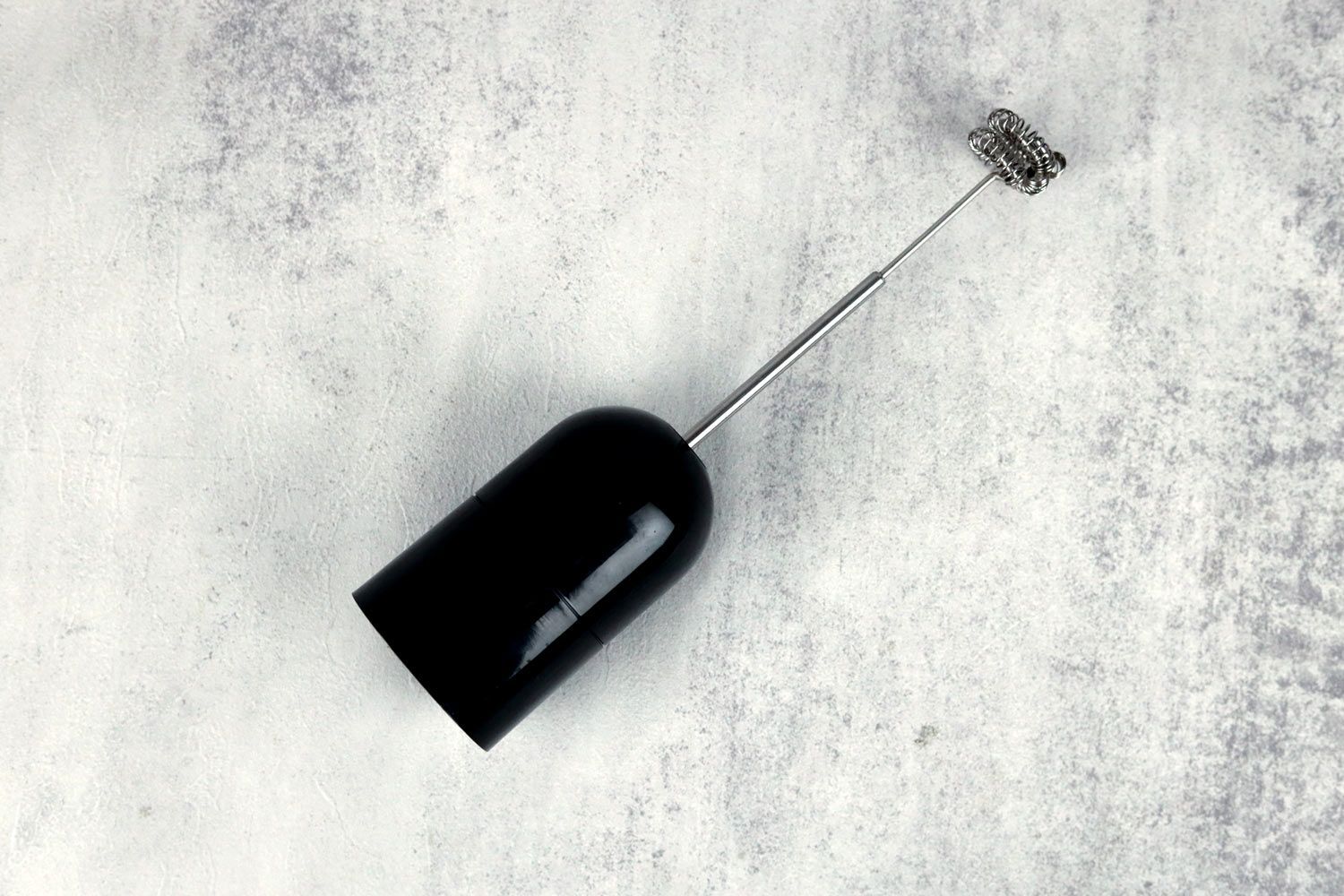 The Mueller Ultra-Stick Immersion Blender Milk Frother Attachment lying flat on a gray table.