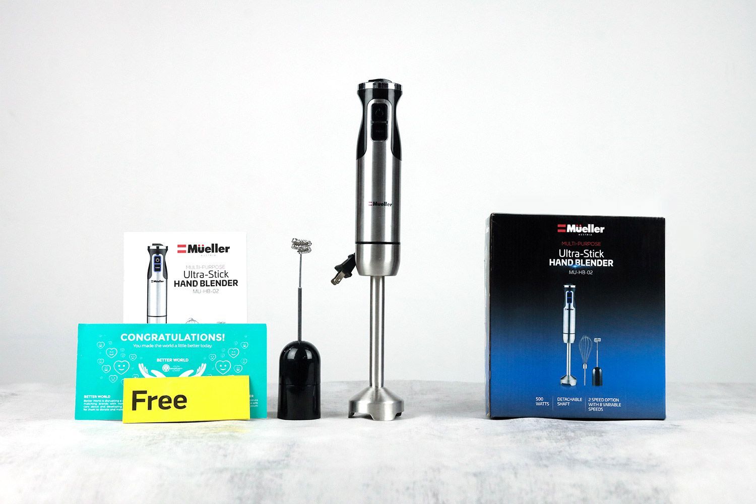 The Mueller Ultra-Stick Hand Blender Set including a milk frother attachment, a whisk attachment, a motor body, a blending wand, a paper carton box, and user manuals. The Mueller Ultra-Stick Hand Blender Set including a milk frother attachment, a whisk attachment, a motor body, a blending wand, a paper carton box, and user manuals.