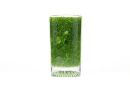 A glass of water combined with fibrous greens pulp produced by the iCucina Single-Serve Blender.