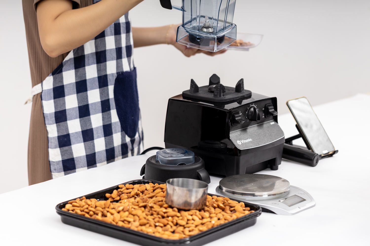 Preparing for an almond butter test with almonds, Vitamix 5200 parts, a scale and a phone for timing.