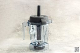 Displayed on a table is the Vitamix E310 blender, complete with its accompanying tamper.