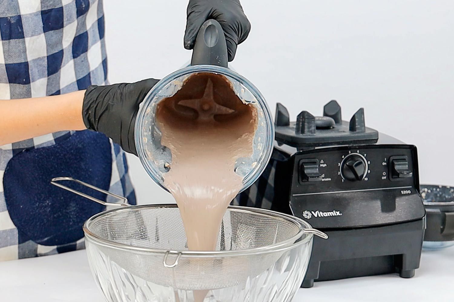 Pouring a smooth mixture from the Vitamix 5200 countertop blender for protein shakes.