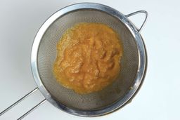 A batch of soup pureéd by the Betty Crocker immersion blender is checked for smoothness by being drained through a stainless steel mesh strainer.