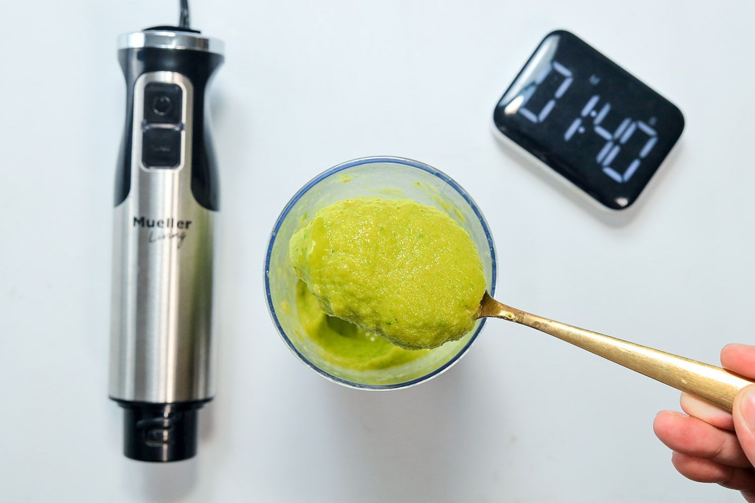 Scooping smoothie to check texture after blending with Mueller 3-in-1 8 Speed