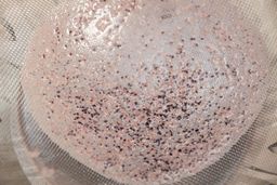Close-up of the Ninja TWISTi protein shake test, showing fine particles and residue left behind after straining through a mesh sieve.
