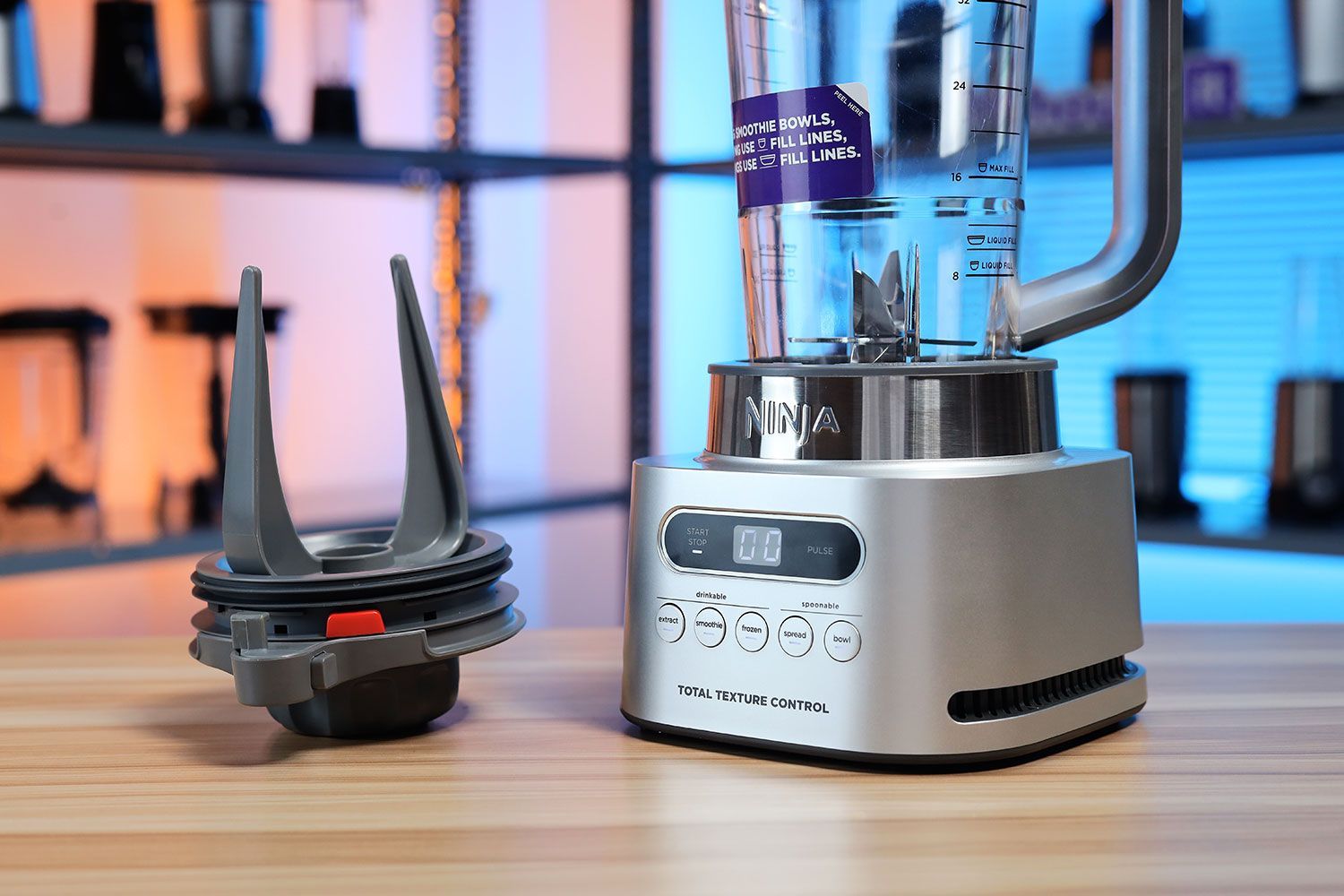 Ninja TWISTi blender built-in tamper lid placed beside the motor base and blending jar.