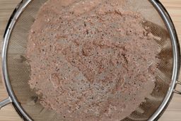 Close-up of the Ninja BL610 protein shake test, showing fine particles and residue left behind after straining through a mesh sieve.