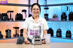 Tina crushes ice with the Ninja SS151 TWISTi Blender Duo. During the test, she twists the built-in tamper to keep ingredients moving, and midway through she uses a spoon to stir the contents for more even crushing. At the end, she pours the crushed ice into a black tray so the texture is easier to see.