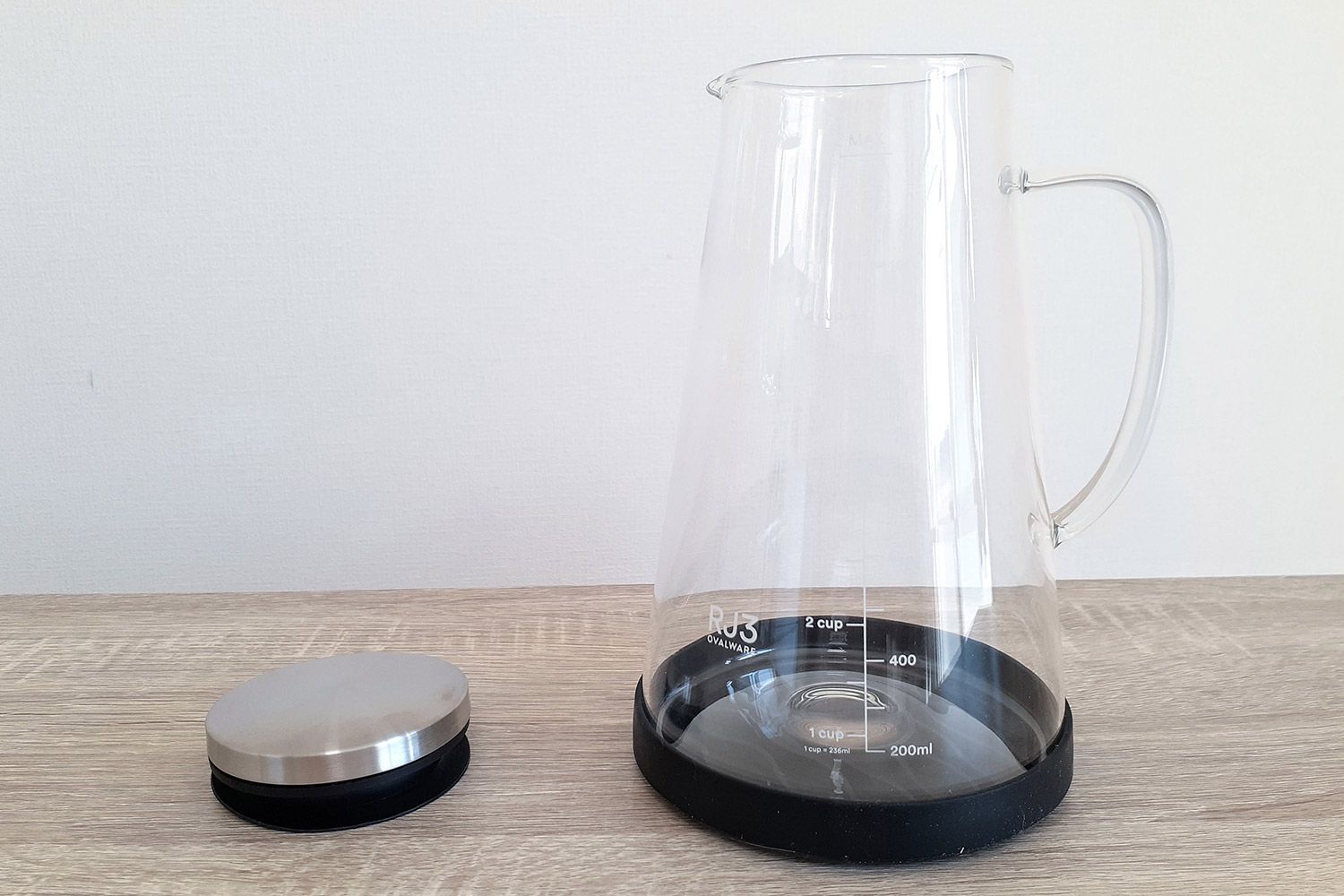 Ovalware RJ3 cold brew coffee maker empty glass carafe with no filter and the stopper resting to the right on the countertop.