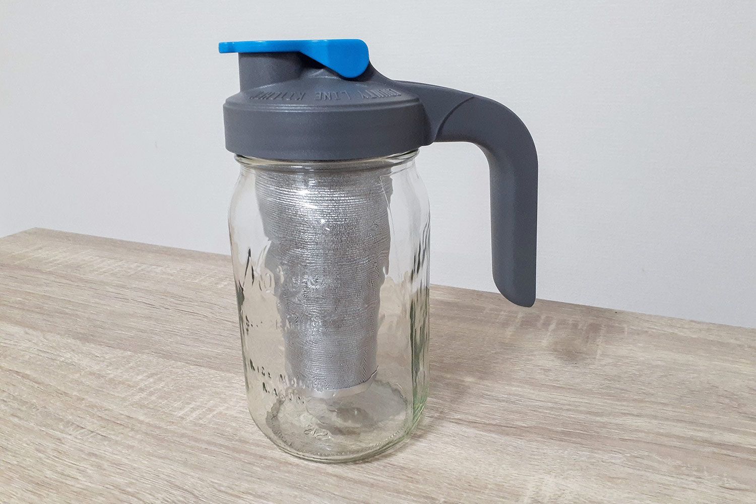 The fully assembled County Line mason jar cold brew coffee maker standing on a wooden countertop.