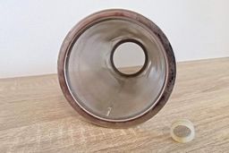 A close up front-view of a gauze filter from a cold brew coffee maker on a wooden countertop.