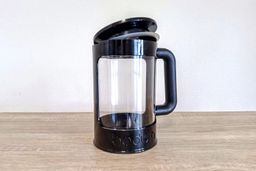 An empty Bodum cold brew coffee maker with its brew lid half resting in place.