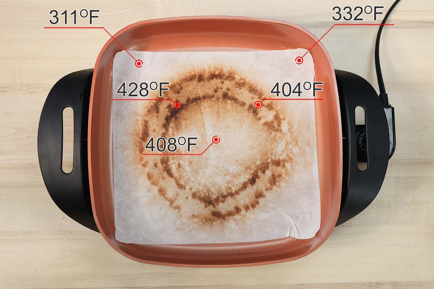 The Bella Non-Stick Electric Skillet 14607 with a white oil-absorbent sheet covering the surface of the pan. The dark double circles indicate where the heating element is.