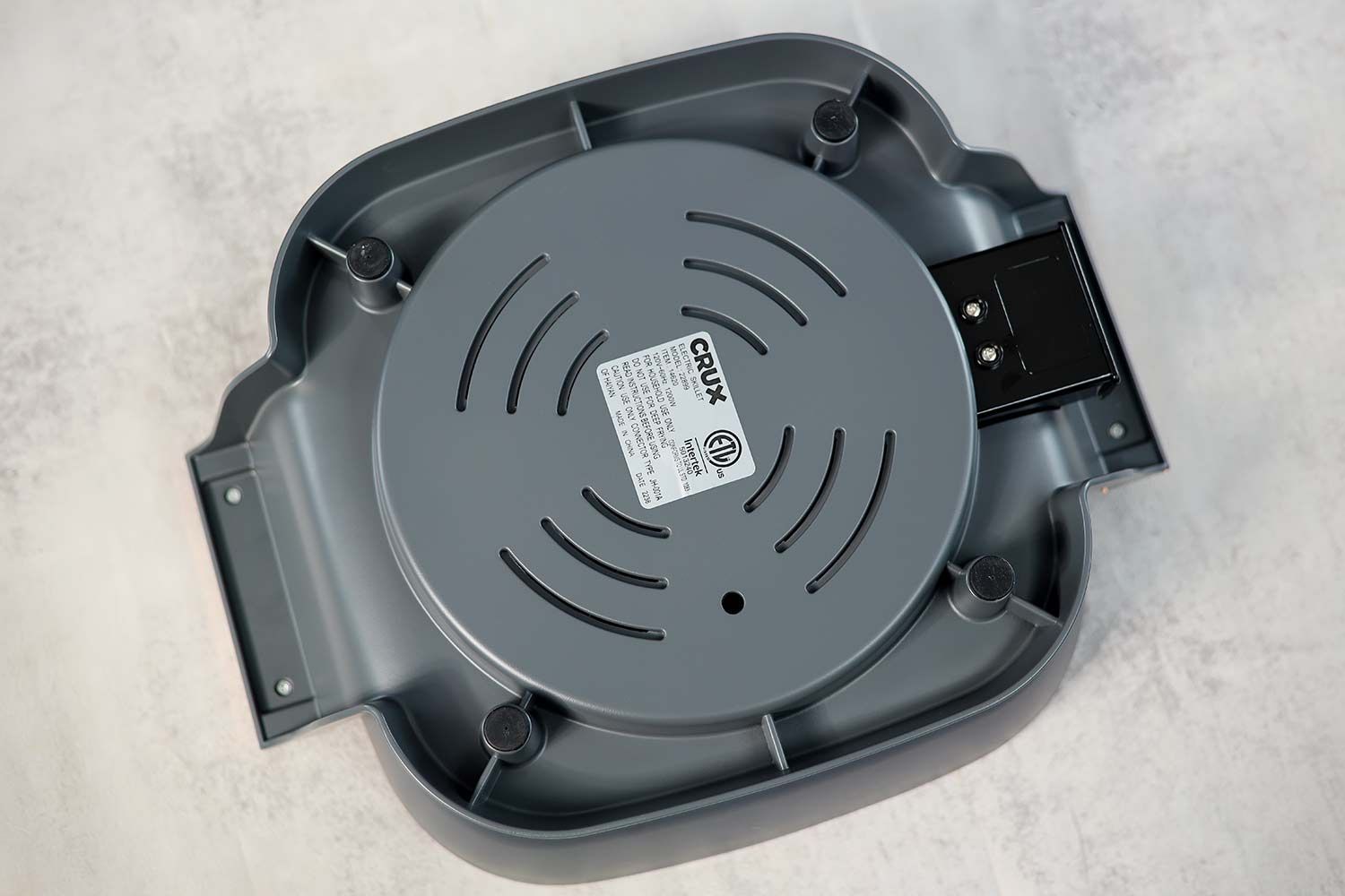 The base of the Crux Non-Stick Electric Skillet 14620 has four stands with anti-slip pads.