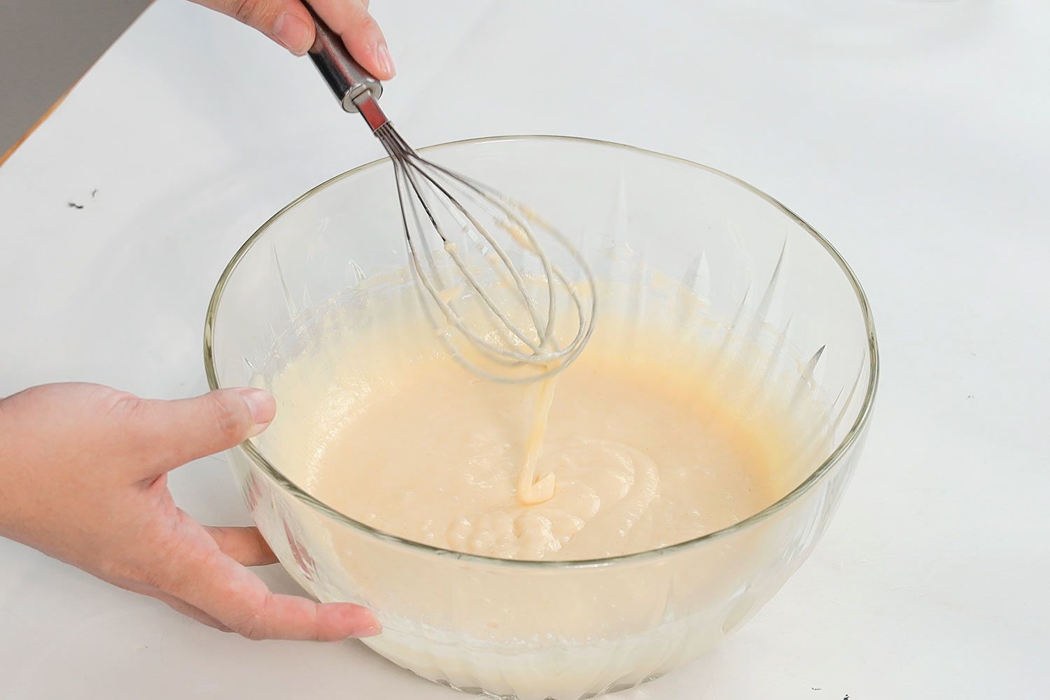 Checking the consistency of the batter with a whisk.