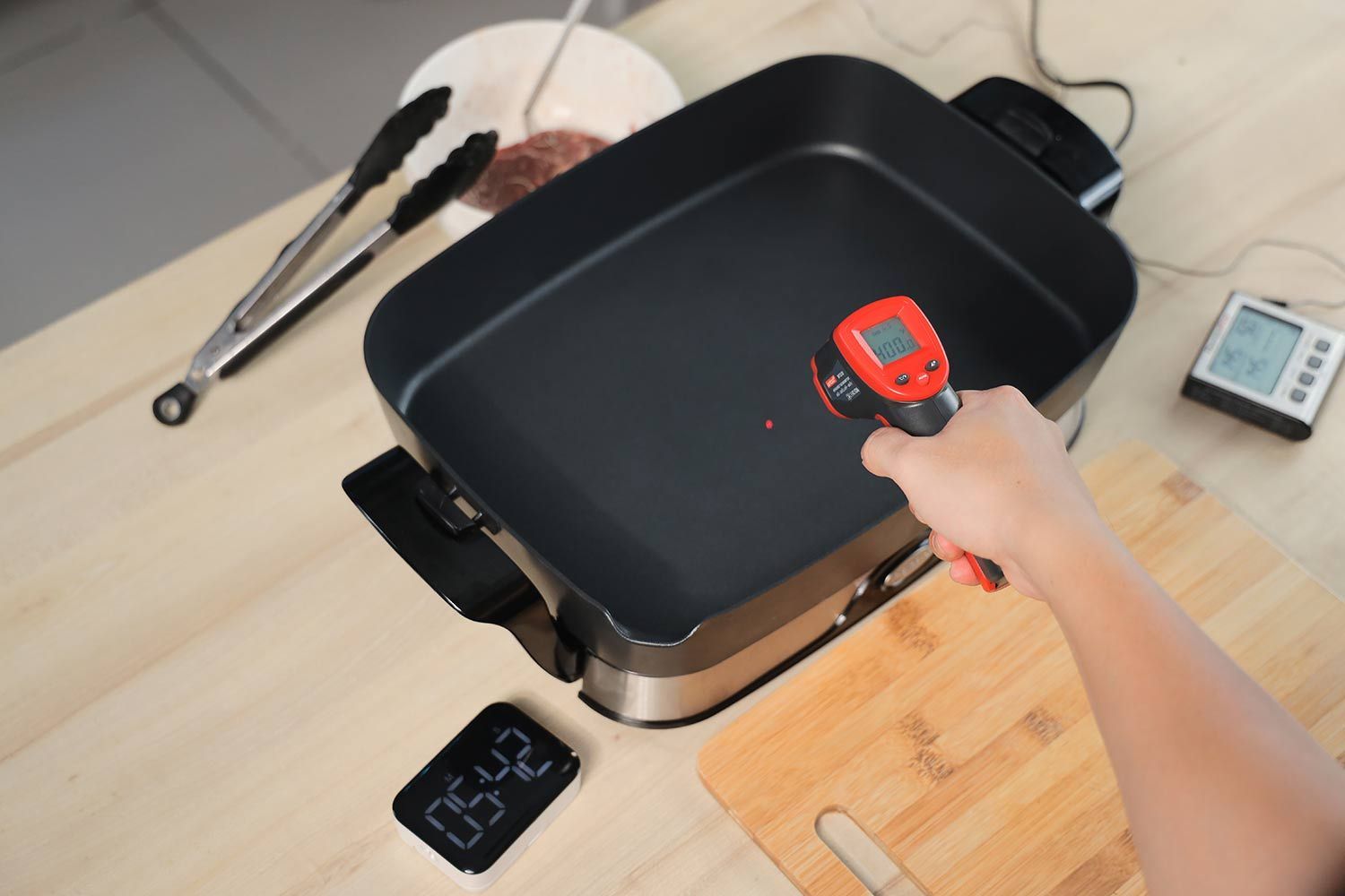 An infrared thermometer reads the temperature on the Presto Foldaway Non-Stick Electric Skillet 06857 to be 400°F.