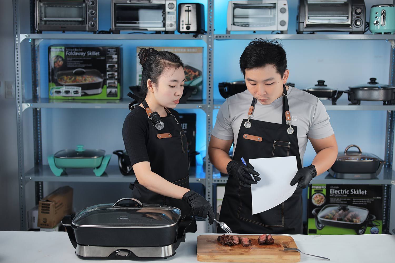 Two people tasting and evaluating a steak made with the Presto Foldaway Non-Stick Electric Skillet 06857.