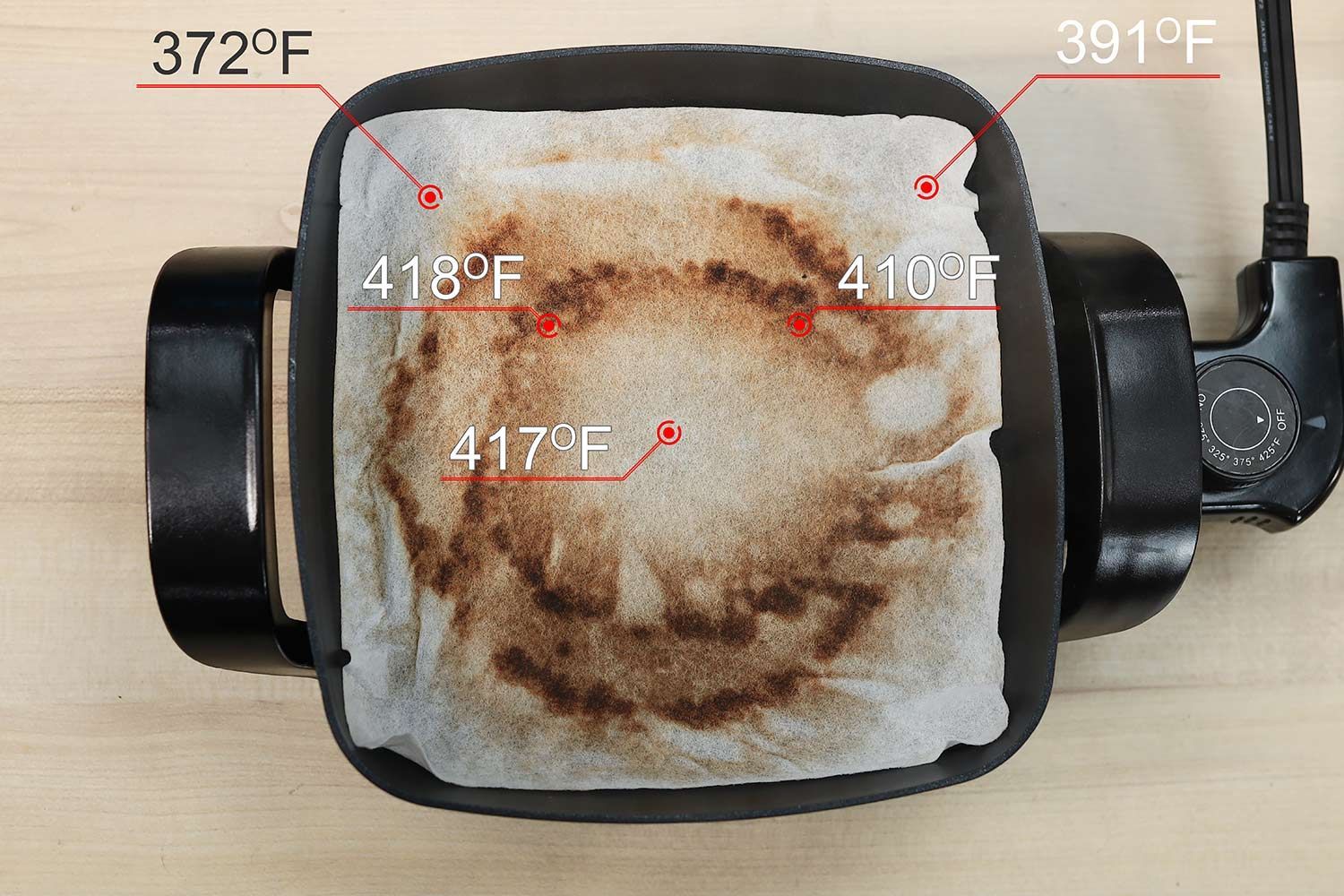 The Nesco Non-Stick Electric Skillet ES-08 with a white oil-absorbent sheet covering the surface of the pan. The dark double circles indicate where the heating element is.