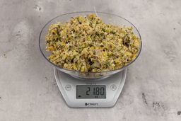 21.8 ounces of assorted ground scraps, including dietary fibers, bones, etc., on digital scale, on granite-looking top.