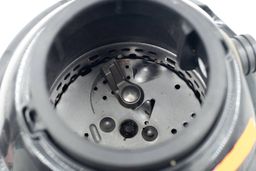 Top view through collar of Disposall GFC720N GE garbage disposal into chamber after testing, looking at layout of grinding components, highlighting swivel impellers, flywheel, and grater/grinder ring.