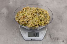 18.34 ounces of fish pin bones in mess of assorted scraps from garbage disposal on digital scale on granite-looking top. 