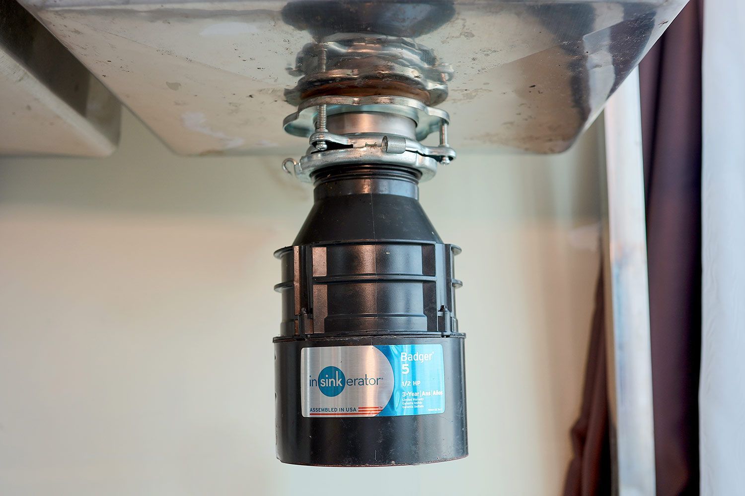 InSinkErator Badger 5 1/2-Horsepower Garbage Disposal hanging under a standalone sink.