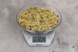 12.19 ounces of fish pin bones in mess of assorted scraps from garbage disposal on digital scale on granite-looking top. 