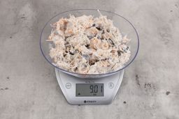 0.92 ounces of ground chicken scraps from garbage disposal, displayed on digital scale, placed on granite-looking table. Mess of shredded soft tissues and shredded bones.