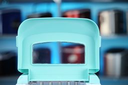 A close up of the underside of an opened lid on a countertop ice maker.