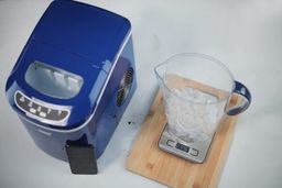 A full basket of ice from the Vivo Home countertop ice maker being weighed in at 576 grams. The ice is in a jug resting on a digital scale.