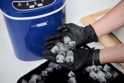 A sample of ice bullets produced from the Vivo Home countertop ice maker held between two gloved hands.