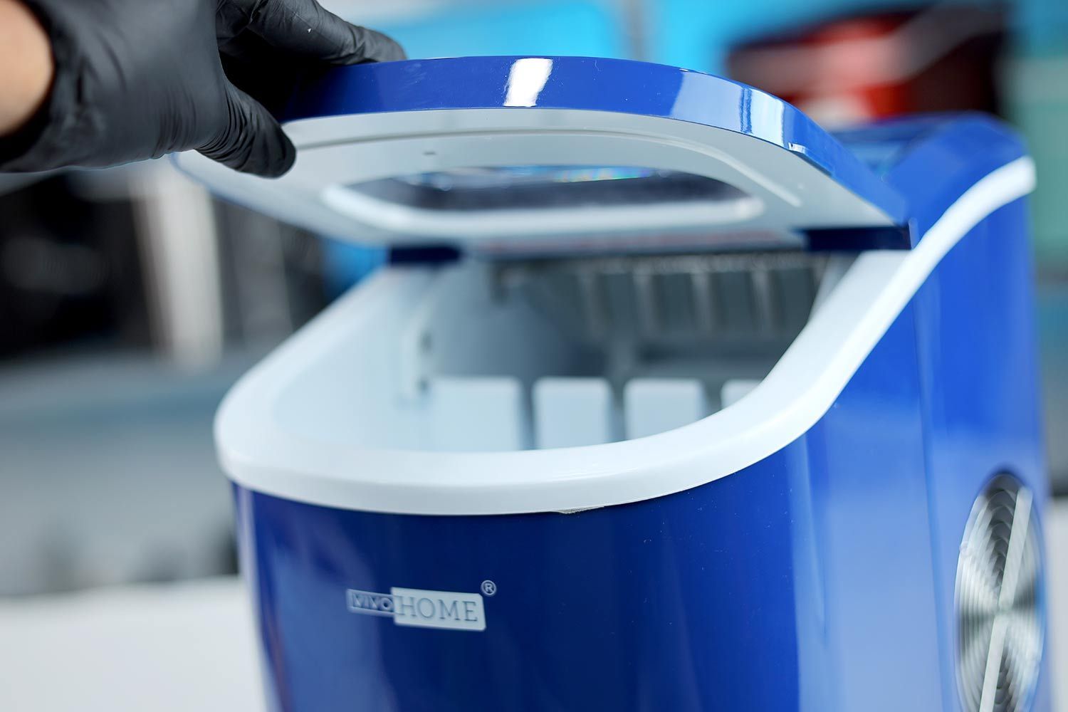 The lid of the Vivo Home countertop ice making machine being held up with black-gloved hand.