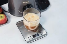 Tray of apples, apple juice on a scale, the Jocuu masticating juicer