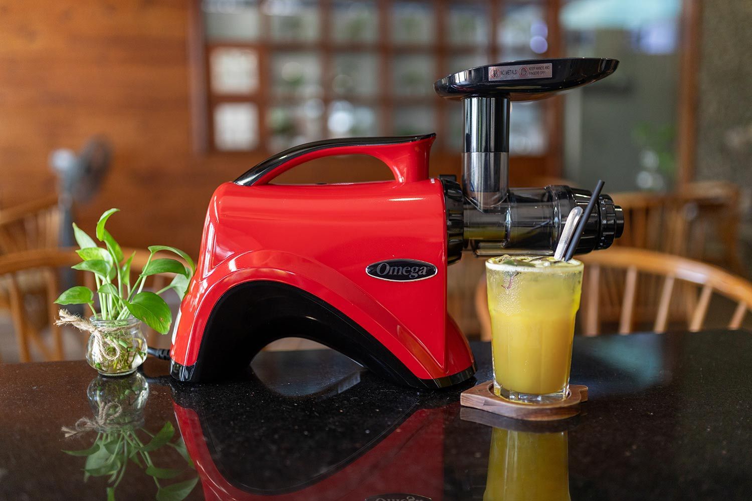 The Omega NC900 masticating juicer and glass of juice