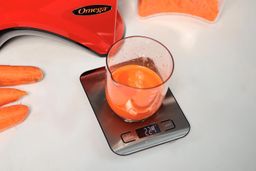 weighing carrot juice on a kitchen scale