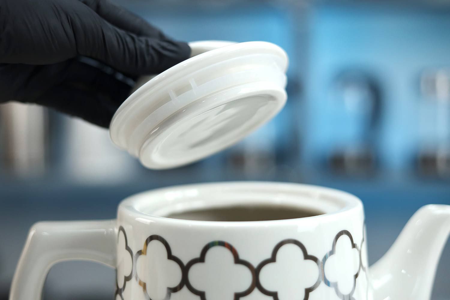 A hand holding the lid of the Bella Ceramic Gooseneck Electric Kettle (14745).