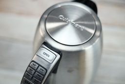 The lid is pop-up button of the Cuisinart Stainless Steel Electric Kettle with 6 Preset Temperatures (CPK-17P1 PerfecTemp) is located on its handle.