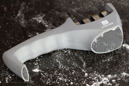 The Amesser A-65 manual sharpener on a salt-sprinkled surface, its base in full view