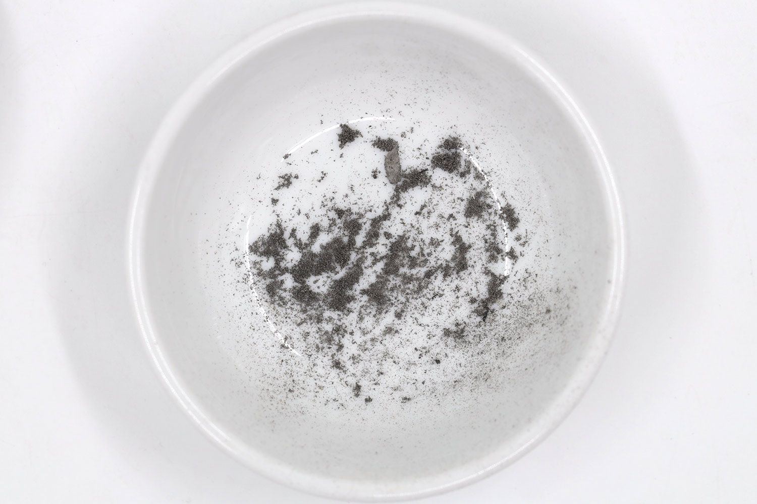 Sharpening residue as metal dust in a white bowl