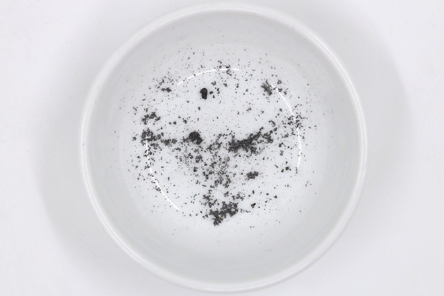 Sharpening residue as metal dust in a white bowl