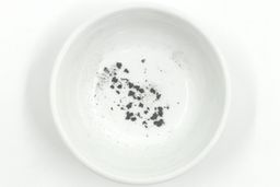 Sharpening residue as metal dust in a white bowl