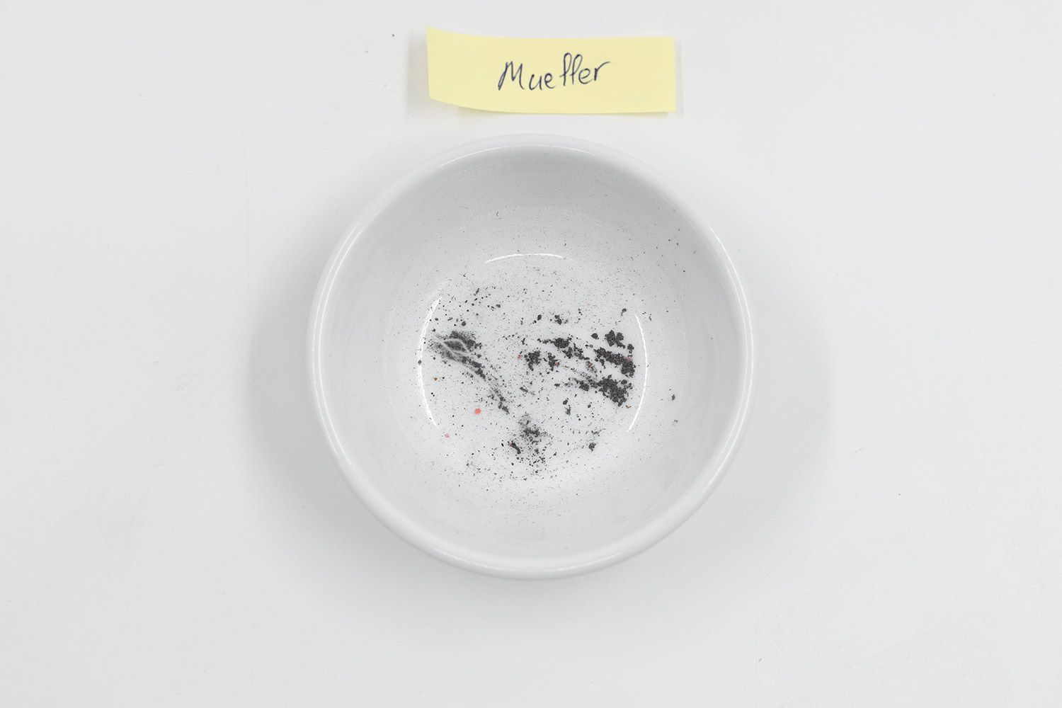 Metal residue in a bowl after sharpening a knife with the Mueller KSE-24 electric sharpener, sticker note