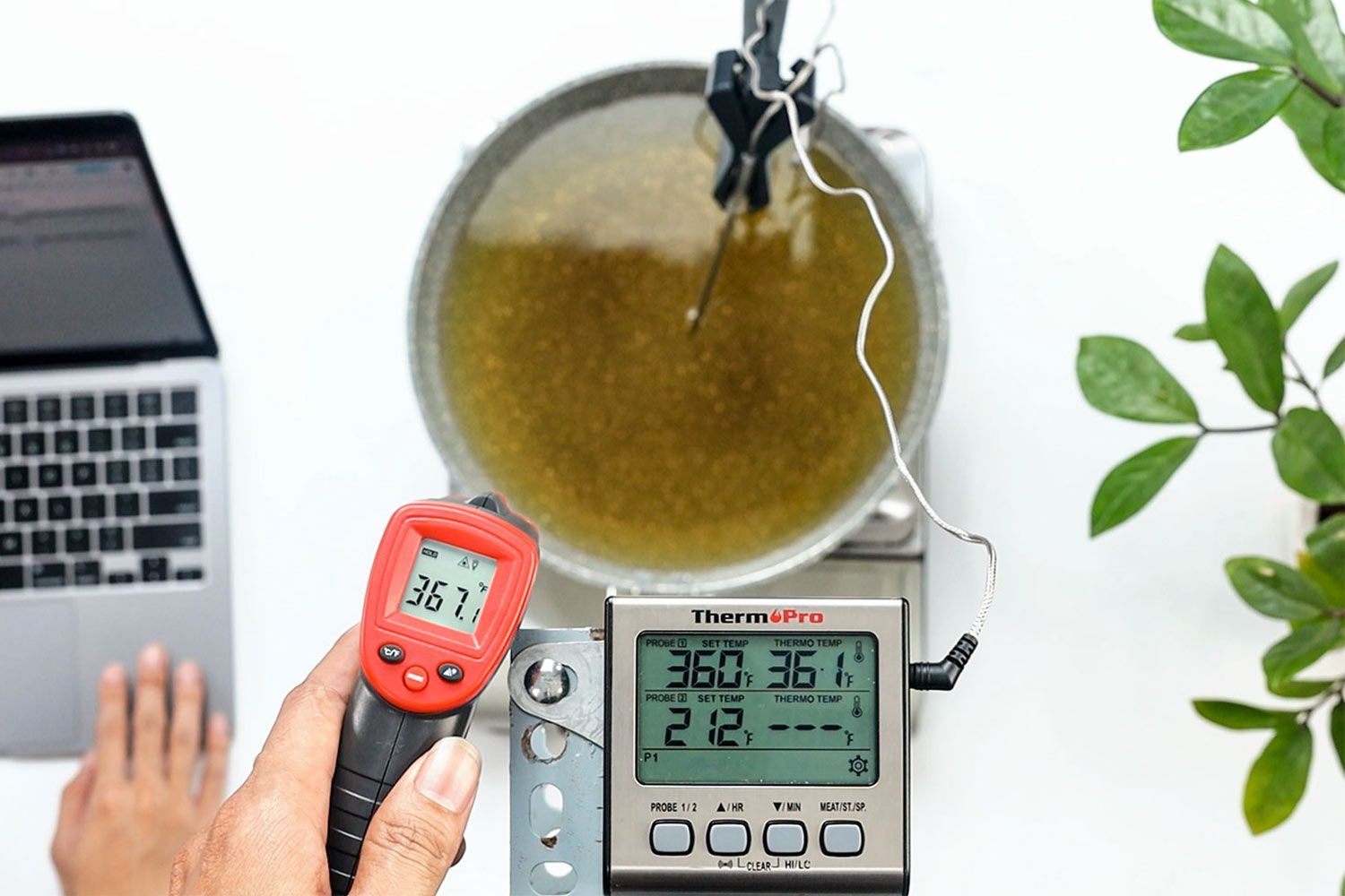 The Eventek GM550 is used by a reviewer at a distance of 16 inches to measure the temperature of a pan of oil. The screen reads 367.1°F.