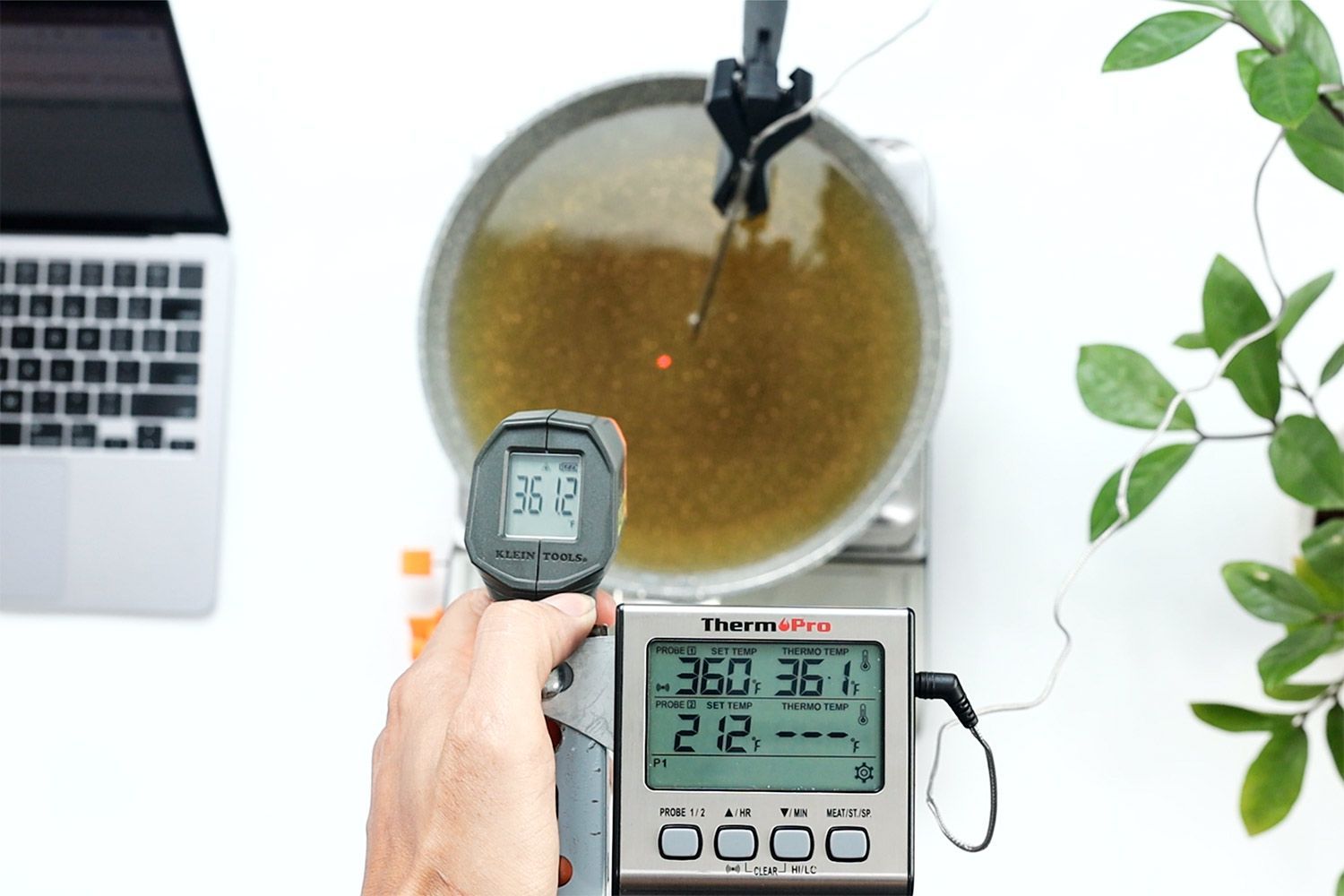 Klein Tools IR1 measures the temperature of a pan of oil. A laser dot indicates the spot being measured on the pan.