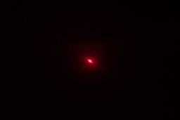 The red laser dot of the Smart Sensor AS530 IR thermometer’s laser emitter in a dark room.