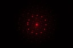 The 13-dot laser pattern of the Sovarcate HS980E on the wall of a dark room.