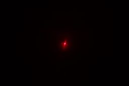 The red dot from the laser emitter of the Wintact WT530 IR thermometer in a dark room.