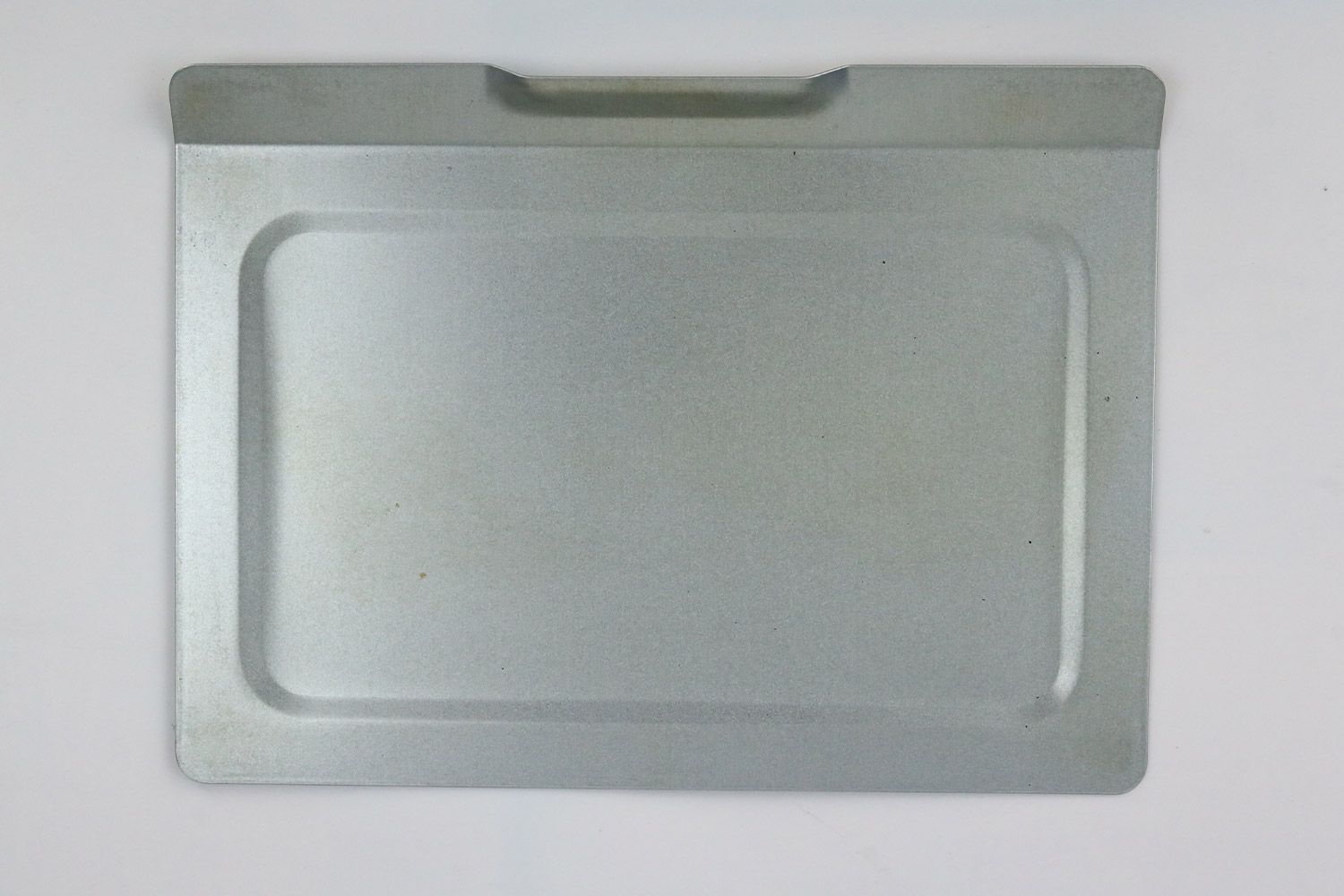 A removable crumb tray of the stainless steel Hamilton Beach 31401 4-Slice Countertop Toaster Oven on a grey background.